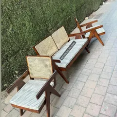 An angled view showing the profile of both the armchair and the two-seater bench.