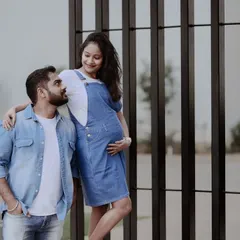 A relaxed and modern maternity shoot with a couple dressed in matching denim. They share a loving look, capturing a casual and authentic moment of their pregnancy journey.