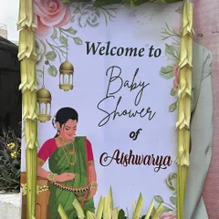 A personalized welcome sign for Aishwarya's baby shower, framed with traditional woven palm leaves and featuring a beautiful illustration.
