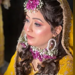 A side profile showing the beautiful floral maang tikka and earrings. The soft curls complete this romantic Haldi look.