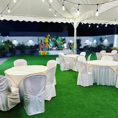 A night view of our venue set up with a large marquee tent and round tables. The clean artificial turf is perfect for any event, ensuring a comfortable experience for guests.
