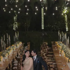 The couple enjoying a quiet moment amidst their beautiful reception setup. The warm glow of the lights creates a romantic and intimate ambiance.