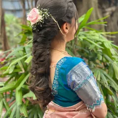 A modern take on a traditional hairstyle for Payal. This features a beautiful, thick braid accessorized with a fresh pink rose and delicate baby's breath.