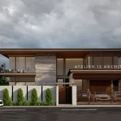 A view of the modern villa from the street, highlighting the private entrance and carport. The facade combines textured stone panels with warm wood accents and a cantilevered upper floor, creating a dynamic composition that is both welcoming and secure.