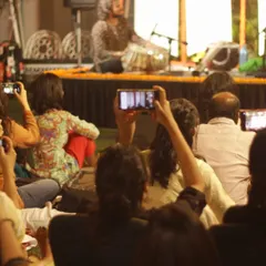 A view from the audience, where everyone is capturing the moment. It shows how personal and engaging these sessions are, with people feeling close enough to the artists to record their favorite parts.