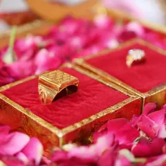 A close-up shot of the engagement rings nestled in their boxes on a bed of rose petals, symbolizing the start of a new journey.