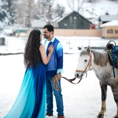 A destination pre-wedding shoot in the snow. I styled the couple in a vibrant blue ombre gown and a coordinated shirt that stands out beautifully against the serene, white landscape.