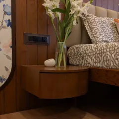A close-up of the custom floating bedside table, designed with curved edges to soften the room's aesthetic.
