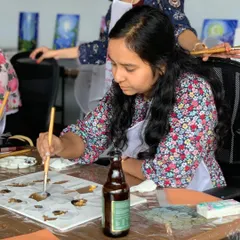 A close-up of a painter adding gold leaf details to her artwork. It's a delicate process that yields stunning, eye-catching results.