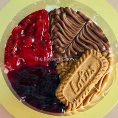 A top-down view of the assorted no-bake cheesecake, showing the vibrant colors of the fruit compotes next to the rich swirls of Nutella and Biscoff.