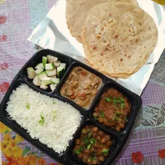 A satisfying North Indian thali with two plain parathas, rich mushroom masala, homestyle chole, plain rice, and fresh guava slices for a complete lunch or dinner.