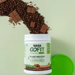 A creative shot for Tata GoFit showing coffee beans and chocolate pouring into the protein powder tub, visually explaining the 'Cafe Mocha' flavor in a dynamic way.