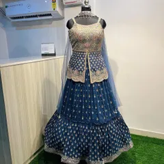 This navy blue jacket lehenga is a unique and stylish choice for a reception. The long, embroidered jacket over a tiered skirt creates a very modern and regal silhouette.