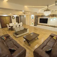 We believe in creating open, inviting living spaces where families can connect. This expansive living and dining area showcases a blend of luxurious leather sofas, elegant lighting, and warm wooden flooring, all designed to create a grand yet comfortable atmosphere for both daily life and entertaining guests.