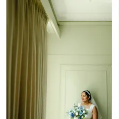 An elegant bridal portrait by a window. The soft, natural light and minimalist background create a serene and sophisticated image.