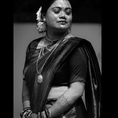 A dramatic black and white portrait of a woman in traditional attire, with light and shadow playing across her face.