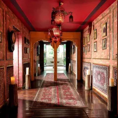 Step into a realm where time-honored traditions intertwine. This corridor, with its rich red walls, Persian rugs, and candlelit path, sets the stage for a royal experience.