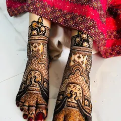 A stunningly intricate design for a bride's feet, featuring peacocks and detailed jaali (net) work. The pattern extends from the toes to the ankles, creating a full and luxurious look.