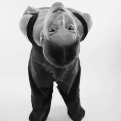 'A BRACA DABRA'. A playful and disorienting black and white portrait shot from a high angle, capturing a quirky and expressive moment.