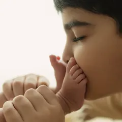 The beginning of a lifelong bond. A brother's gentle kiss on his new sibling's tiny foot is a story of love that needs no words. Capturing these first chapters is a true blessing.