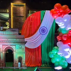 A Republic Day photo booth featuring a replica of the India Gate, a tri-color balloon arch, and a backdrop of saffron, white, and green drapes. It's a perfect spot for capturing patriotic memories.