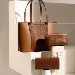A beautifully styled composition of a matching handbag, pouch, and wallet set. The use of artistic props and clean, architectural lines gives the collection a sophisticated and modern gallery feel.