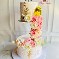 A modern design for a Mr. & Mrs. This unique S-shaped floating cake features two separate tiers connected by a cascade of pink and white roses, creating a stunning visual effect for a wedding or reception.
