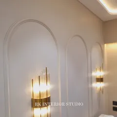 A close-up of beautiful wall sconces against an arched wall moulding. The right lighting can completely transform the mood of a room.