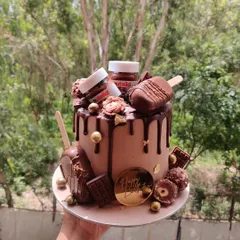 For the ultimate chocolate lover, I present the Nutella overload cake. This creation is dripping with rich chocolate ganache and loaded with Nutella jars, cakesicles, Ferrero Rocher, and chocolate bars for a truly decadent experience.