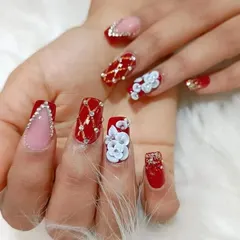 A close-up shot focusing on the detailed 3D floral work and crystal placement on this stunning red and pink bridal manicure.