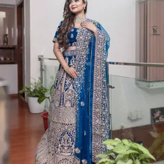 A full view of the magnificent peacock blue bridal lehenga, showcasing the intricate embroidery that covers the entire skirt and blouse.