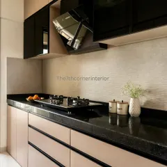 A stylish kitchen design featuring two-tone cabinetry with glossy black upper cabinets and matte beige lower cabinets. The black granite countertop and textured backsplash create a sophisticated and modern look.