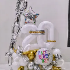 A personalized balloon bouquet for a 20th birthday, with the name 'DIVIT' in foil letters and a mix of gold, silver, and white balloons.