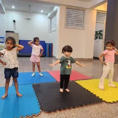 Our tiny dancers, aged 2-4, learning a new pose. We create a playful environment with colorful mats where they can learn basic dance postures safely.