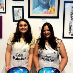 Two friends showing off the beautiful resin koi pond art they made. Our workshops are a great way to catch up and try something new together.