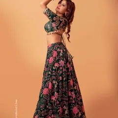A professional shot of the green and pink floral lehenga. The backless blouse design with tassel ties adds a modern and stylish touch to this ethnic outfit.