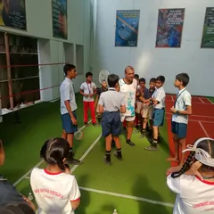 It's all about teamwork and listening. Our coach guiding the kids through the next set of badminton drills.