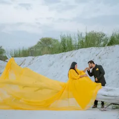 A tender, chivalrous moment amidst a surreal landscape. The flowing gown adds a touch of fairytale magic to this romantic pre-wedding photograph.