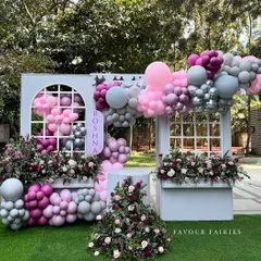 A whimsical bridal shower setup we designed, combining soft pink and grey balloons with beautiful fresh flowers. The custom window-pane backdrop and floral arrangements created a picture-perfect spot for the bride-to-be.
