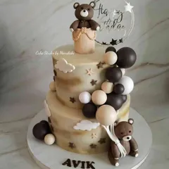 A two-tier first birthday cake in muted, earthy tones as requested by the client. The design features cute teddy bears and a cascade of balloons.
