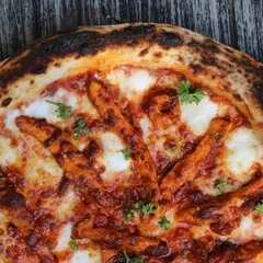 A close-up on the beautiful, charred crust of one of our Neapolitan pizzas. Those leopard spots are a sign of a perfectly baked, wood-fired pizza.