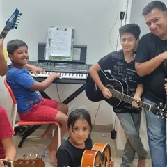 **A Band of Young Rockstars.** Look at the excitement on their faces. Jamming with their mentor and fellow students is an invaluable experience that builds teamwork and social skills.