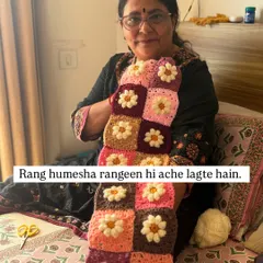 "Rang hamesha rangeen hi ache lagte hain." (Colors always look good when they are colorful). Holding a piece made of daisy granny squares in a beautiful palette of pinks and browns.