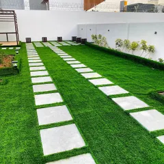 A clean and modern driveway solution using a combination of materials. We laid down premium artificial turf and embedded large, light-colored stone pavers to create a durable and visually appealing path.
