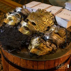 In true speakeasy style, every guest received a masquerade mask upon entry. This collection of ornate gold, silver, and black masks was displayed on a rustic barrel, adding to the theme's authenticity.