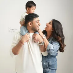A classic family pose filled with so much love and laughter. With their son on dad's shoulders, this family's happiness is infectious in this clean and modern studio portrait.
