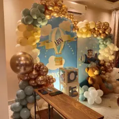 This hot-air balloon and teddy bear themed decoration was for Arin's first birthday. I created a full backdrop with a custom print and surrounded it with a balloon arch in gold, yellow, and pastel blue, adding 'ONE' display boxes and teddy bears.