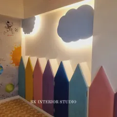 A close-up of the custom headboard, designed to look like a colorful picket fence with backlit cloud cutouts on the wall.