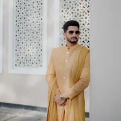 A confident groom ready for his wedding day. The modern sherwani and sunglasses create a cool, contemporary vibe.
