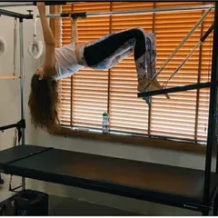 A bridge variation on the Cadillac trapeze table challenges your stability while strengthening your glutes, hamstrings, and back. This move promotes spinal mobility and core strength.